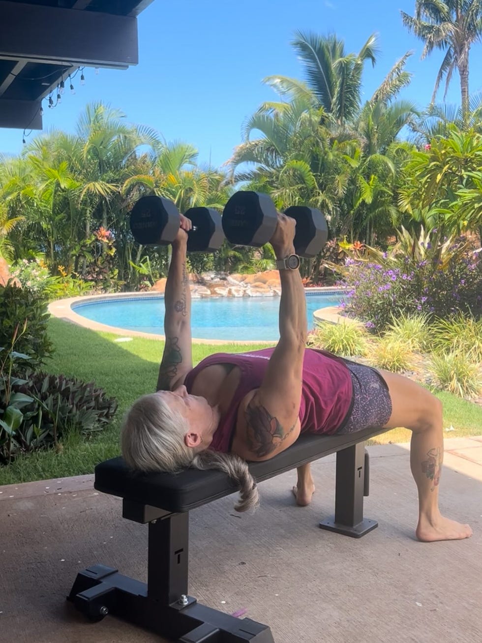 individual performing a dumbbell exercise outdoors