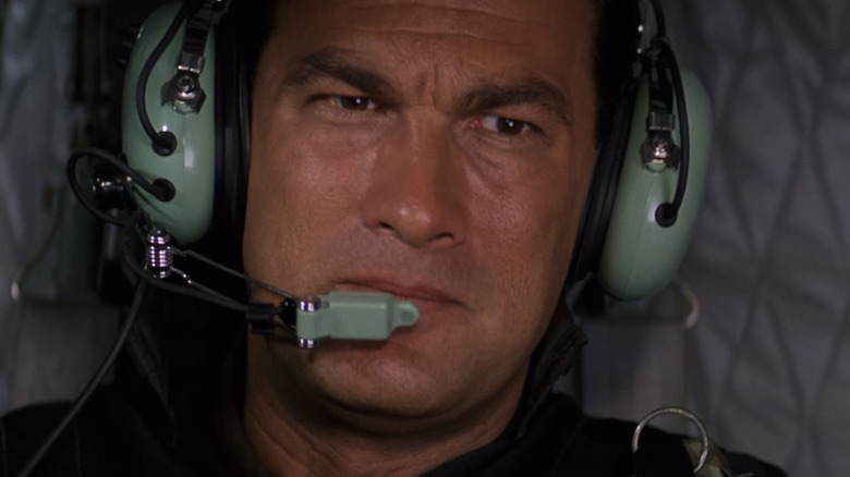 Steven Seagal as Lieutenant Colonel Austin Travis wearing a pilot headset in Executive Decision