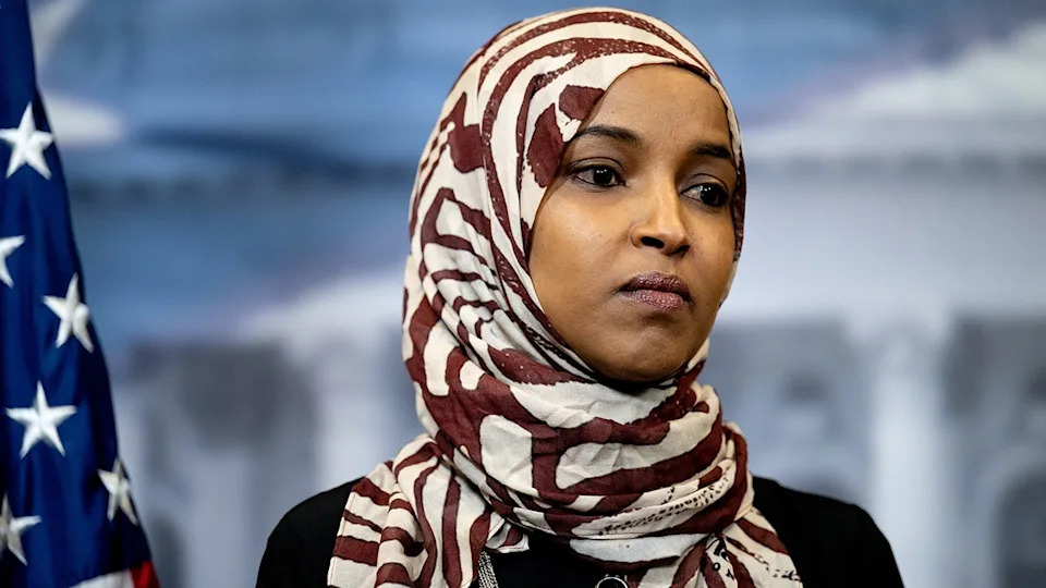 Ilhan Omar standing with a serious expression