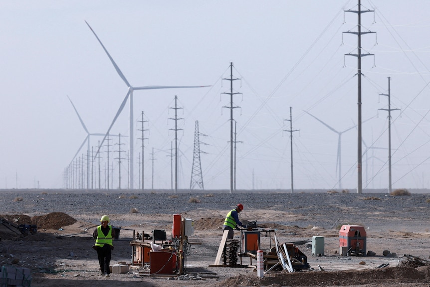 Workers work at a wind farm construction site.