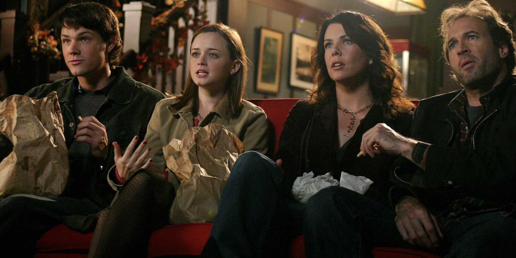 Dean, Rory, Lorelai, and Luke sitting on a couch and watching a movie in Gilmore Girls season 5