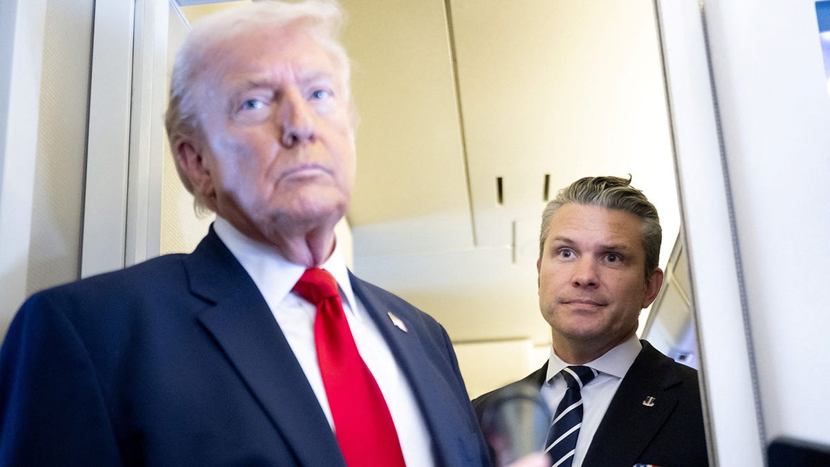 President Trump and War Secretary Pete Hegseth stand before reporters