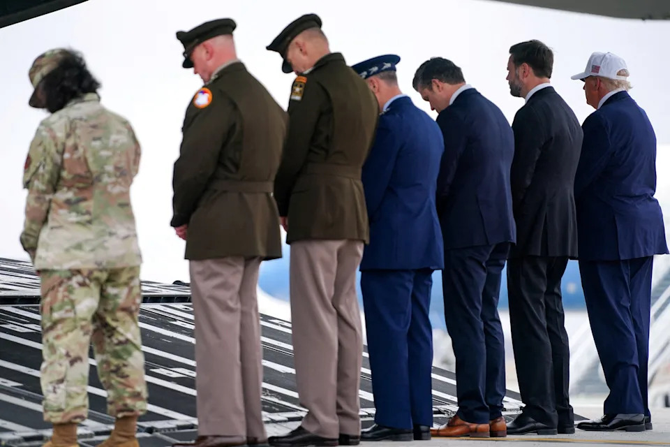 Trump stands without bowing his head while attending the dignified transfer. / Nathan Howard / REUTERS