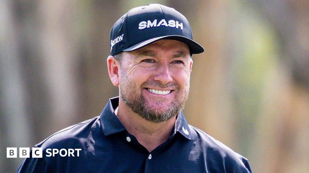 A smiling Graeme McDowell wears a dark cap and open-necked shirt