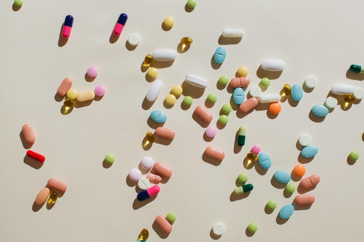 colorful pills and capsules on beige background. minimal medical concept. flat lay, top view.