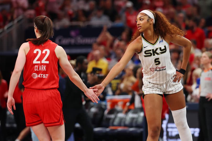 Angel Reese #5 of the Chicago Sky and Caitlin Clark #22 of the Indiana Fever meet at mid court prior to tipoff
