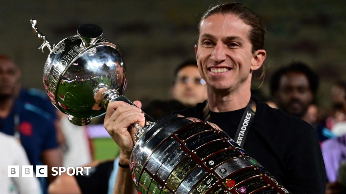 Filipe Luis poses with the Copa Libertadores trophy