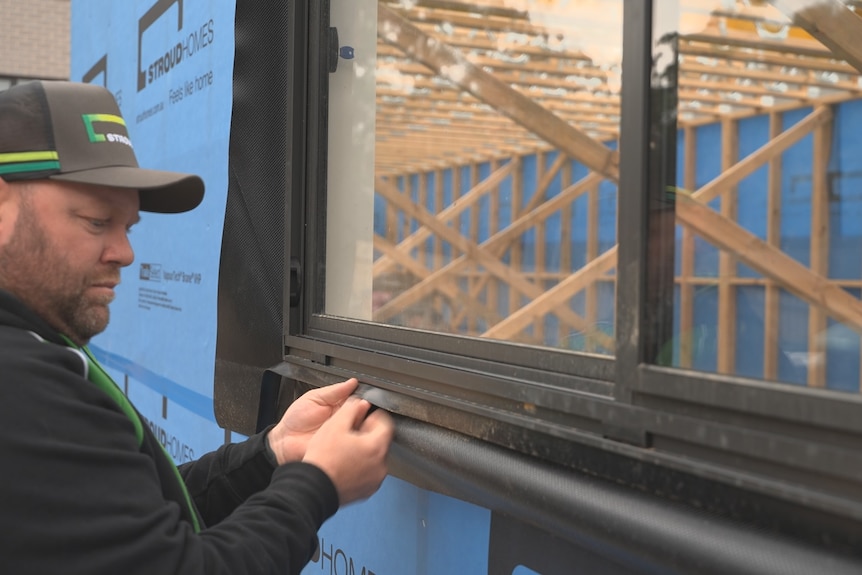 a builder adjusting a window frame