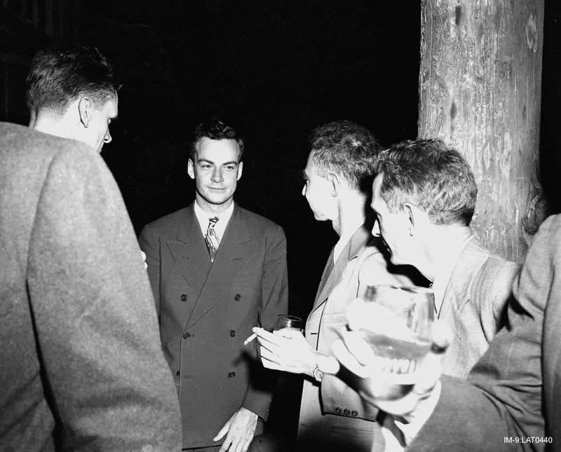 Feynman (center) with Robert Oppenheimer (immediately right of Feynman) at a Los Alamos Laboratory social function during the Manhattan Project. (CREDIT: Wikimedia / CC BY-SA 4.0)