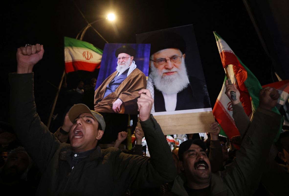 Protesters shout slogans as they carry portraits of Khamenei and wave Iranian flags near the US embassy in Baghdad on February 28.