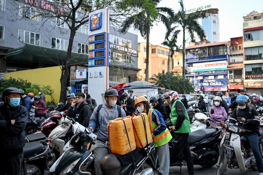Motorists queue to pump gasoline into their vehicle and oil containers at a gas station in Hanoi, Vietnam, on March 10, 2026.
