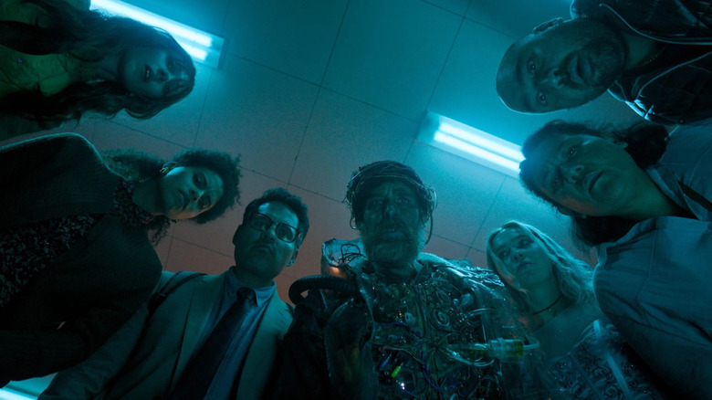 Sam Rockwell as the Man From the Future and his allies gathered in a circle in Good Luck, Have Fun, Don't Die