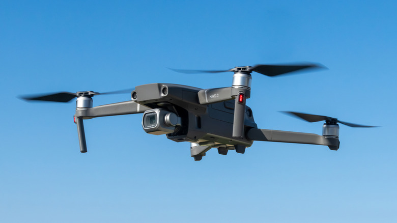 A drone flying against a blue sky.
