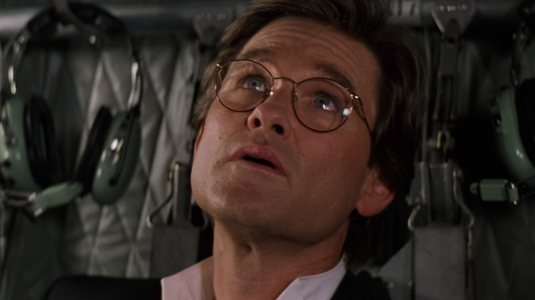 Kurt Russell as Dr. David Grant looking up while wearing glasses in Executive Decision