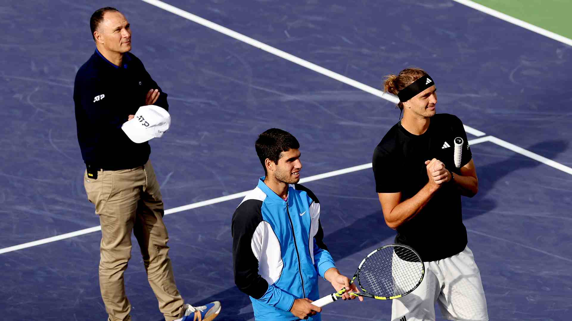 Umpire Mohamed Lahyani, Carlos Alcaraz and Alexander Zverev all wait while play is halted due to a bee invasion at Indian Wells in 2024. 