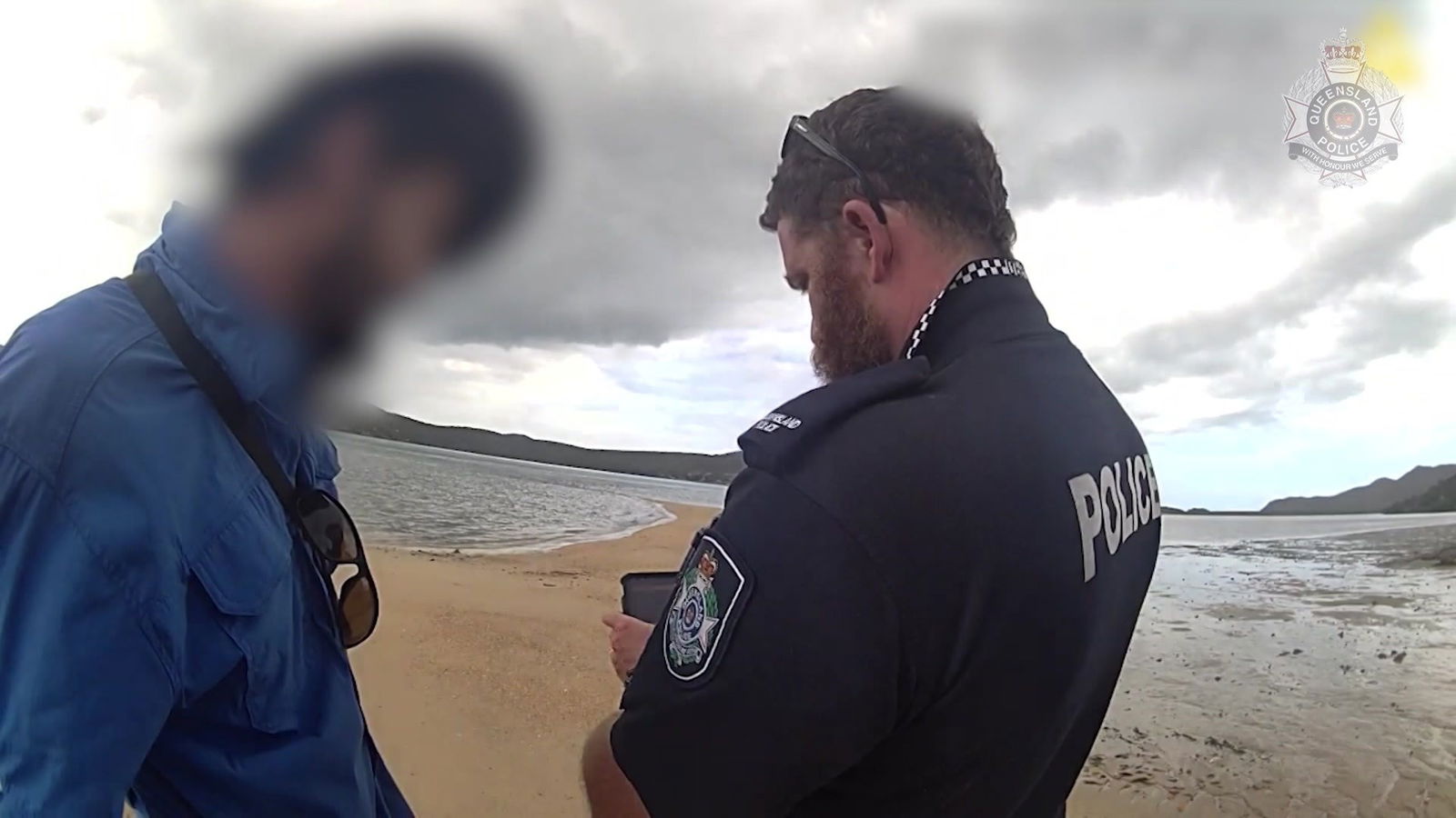police officer speaking to a man on the beach