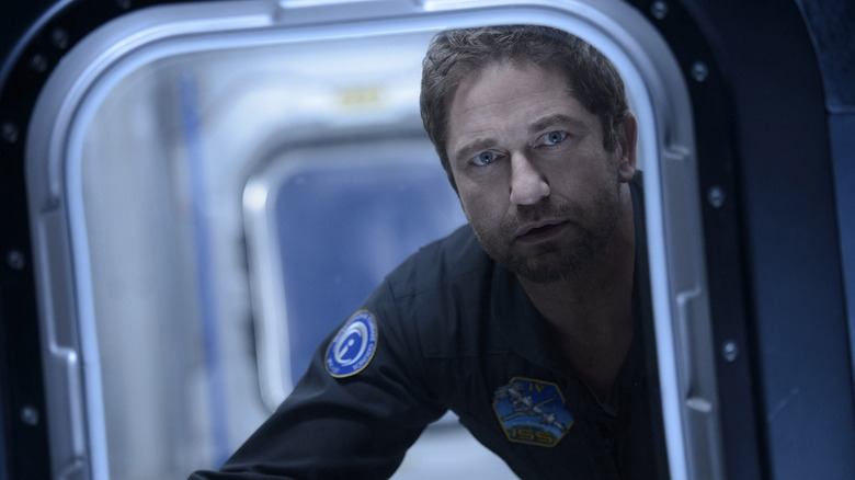 Gerard Butler as Jake Lawson looking out the window of a spaceship in Geostorm