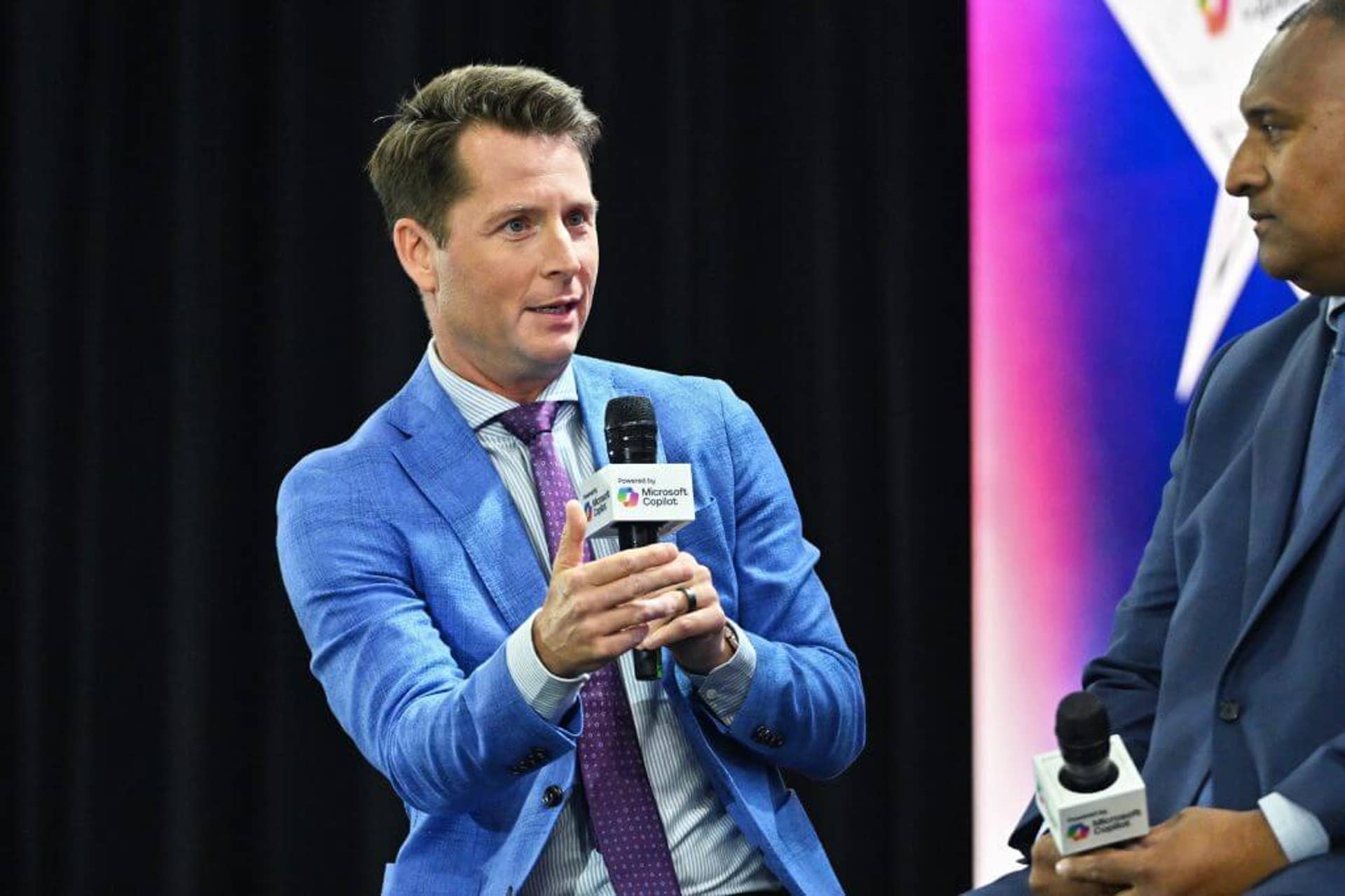 Matt Barrie (left) moderates a coaches roundtable at Big 12 Media Days in 2025.