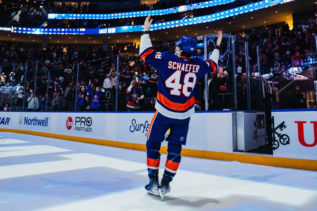 Matthew Schaefer celebrates with the crowd after being named the first star of the game against the Florida Panthers.
