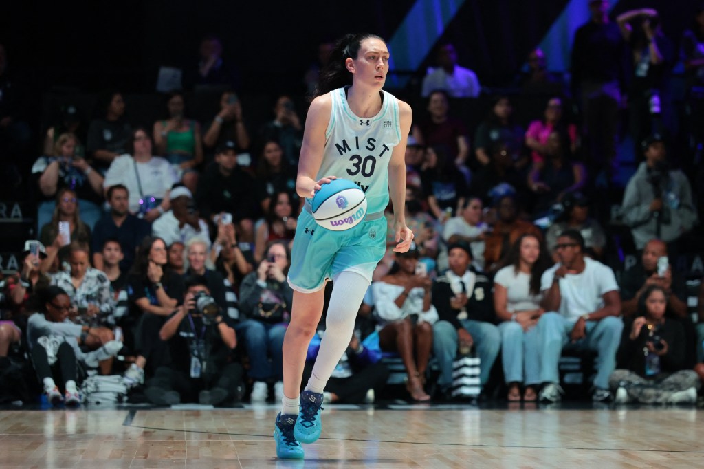 Breanna Stewart dribbles a basketball in a stadium.