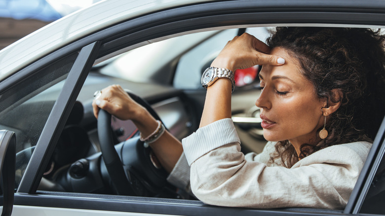 An annoyed driver with her hand on her forehead