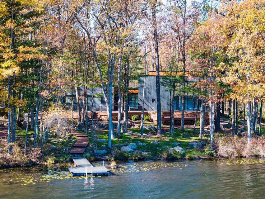 Photo of the Mountain Home in Hawley by EMAKI seen from a distance through trees and over a lake