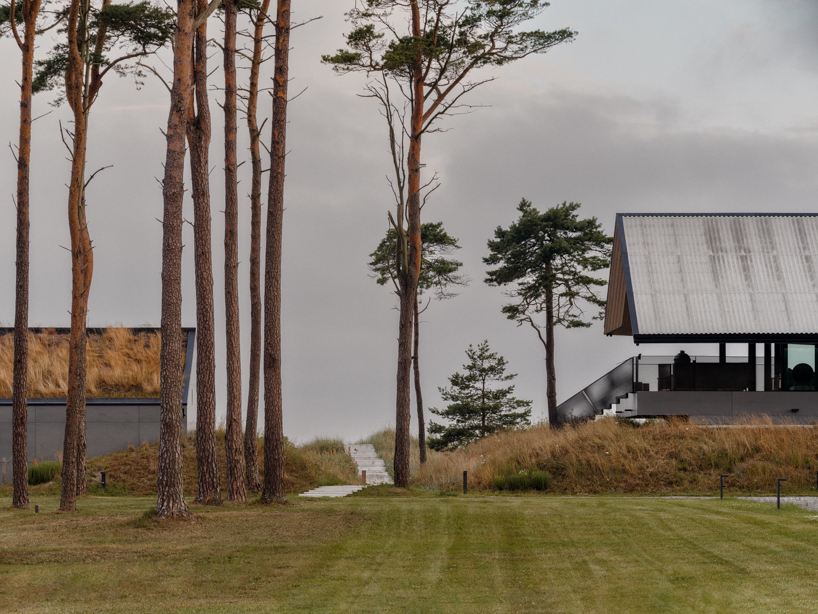 grass-covered seaside family home repurposes abandoned soviet military bunkers in latvia - 1