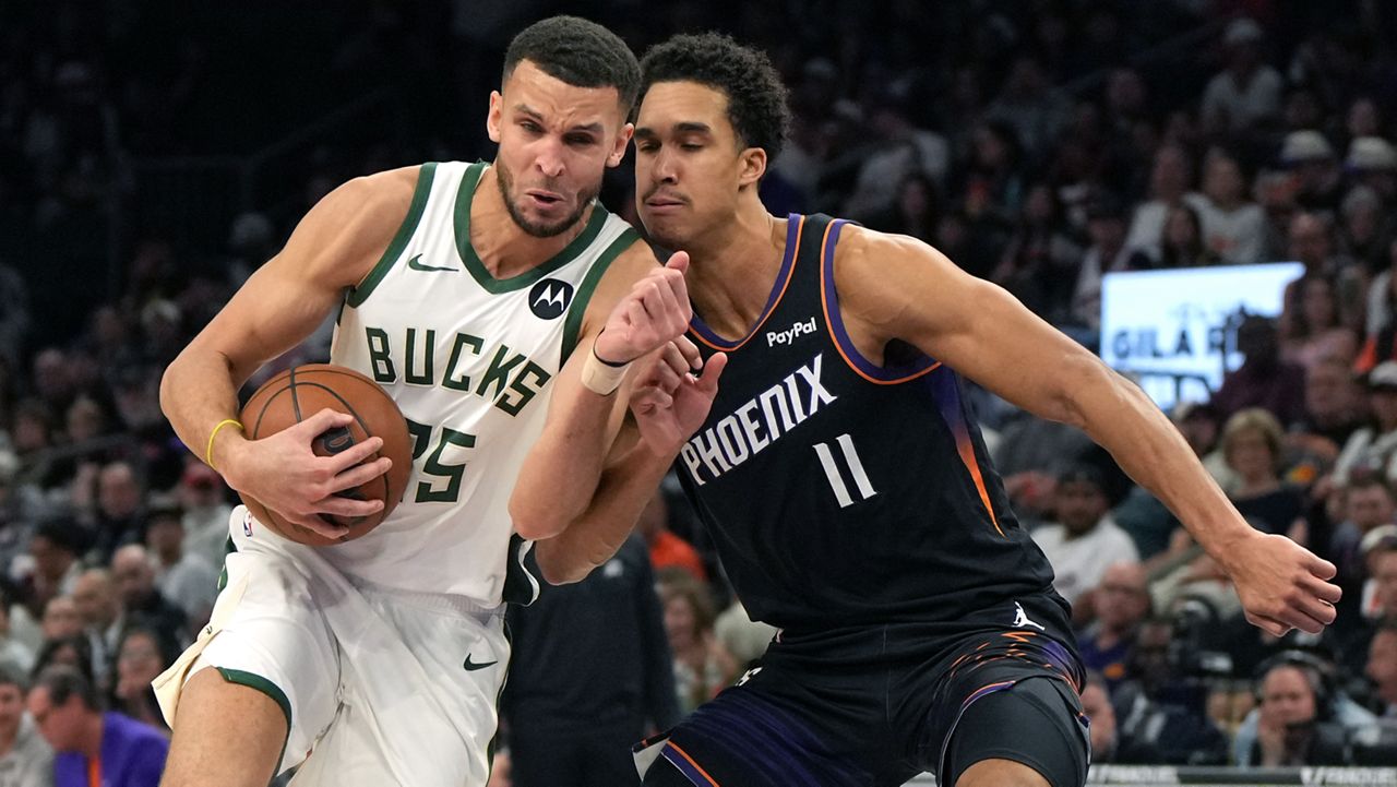 Milwaukee Bucks forward Pete Nance drives on Phoenix Suns forward Oso Ighodaro (11) during the first half of an NBA basketball game, Saturday, March 21, 2026, in Phoenix.