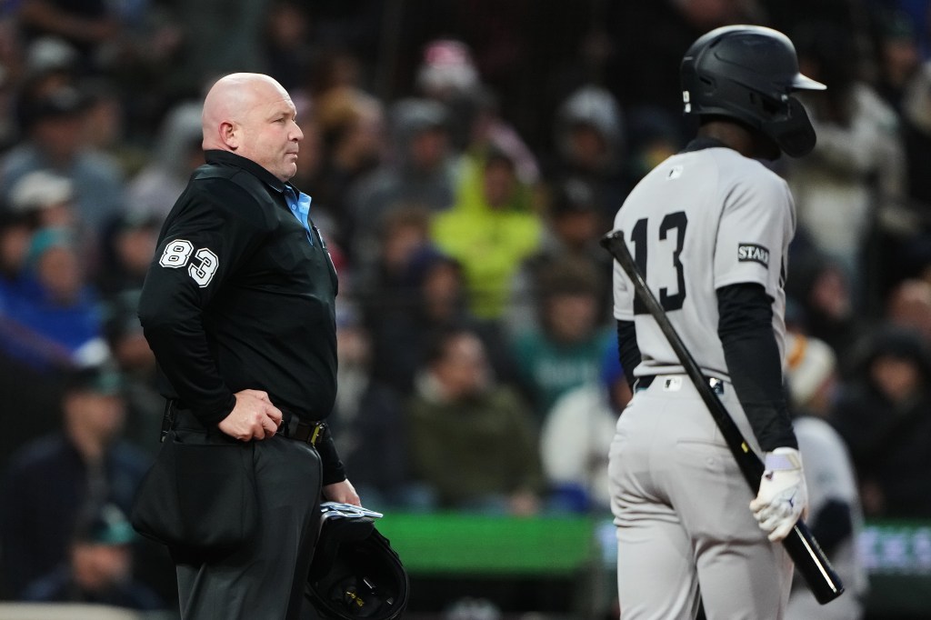 Mike Estabrook (83) reacts as New York Yankees' Jazz Chisholm Jr. challenges a call during the fourth inning of a baseball game against the Seattle Mariners, Monday, March 30, 2026, in Seattle.