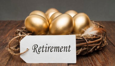 Group of golden eggs sitting inside of a bird's nest with a tag attached that reads 'retirement' depicting a solid retirement nest egg and long-term savings plan