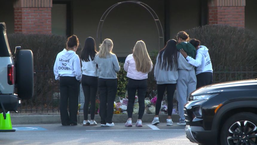 Students gather around a makeshift memorial for Hughes in Hall County, Georgia.