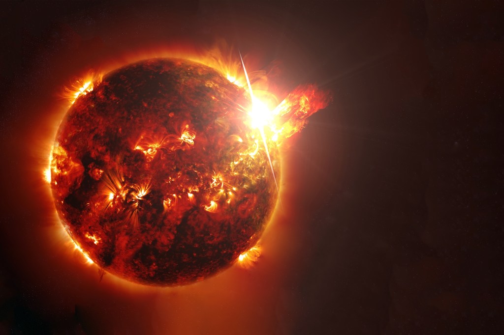 The Sun with a large solar flare and coronal mass ejection against a dark starry background.