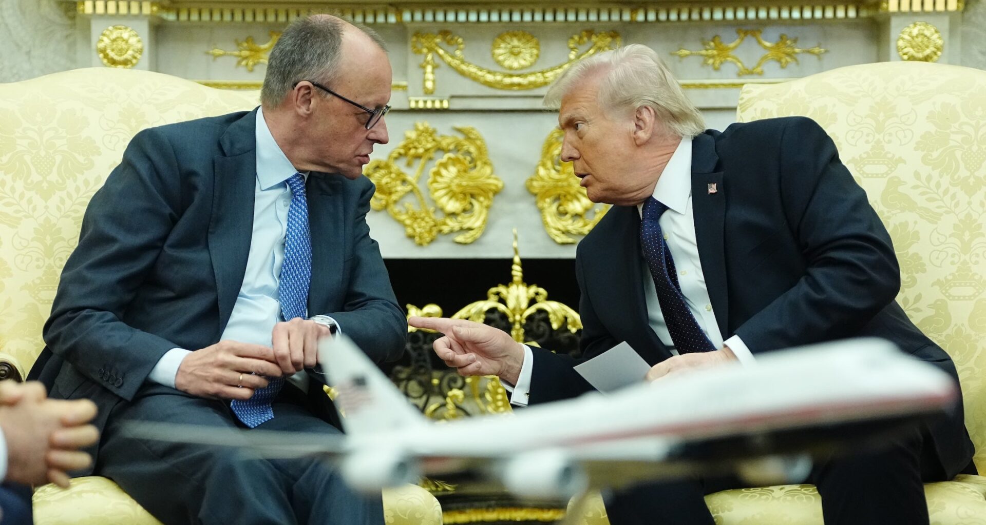 A photo of Merz and Trump speaking to each other.