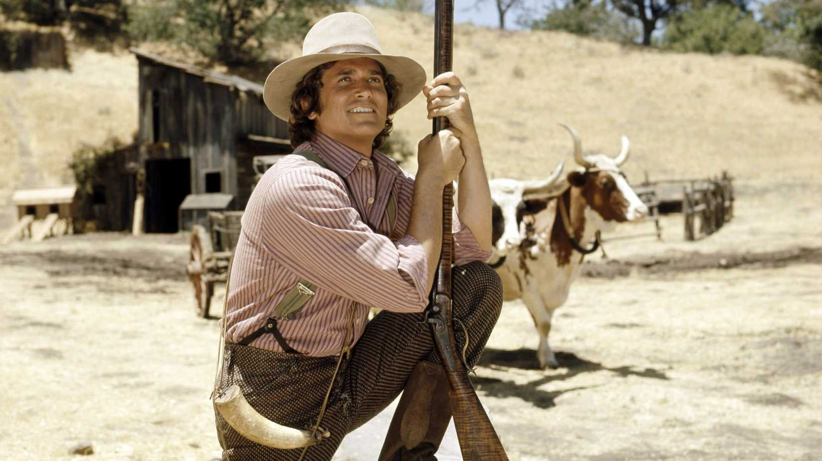 Michael Landon as Charles Ingalls leaning on his gun smiling in Little House on the Prairie (1974)