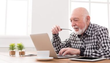 A smiling person at a laptop.