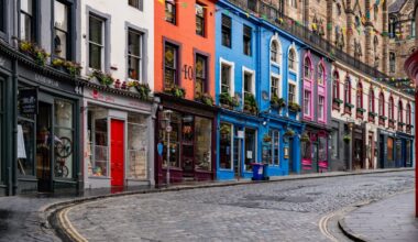 Brick street lined with a row of colorful homes.