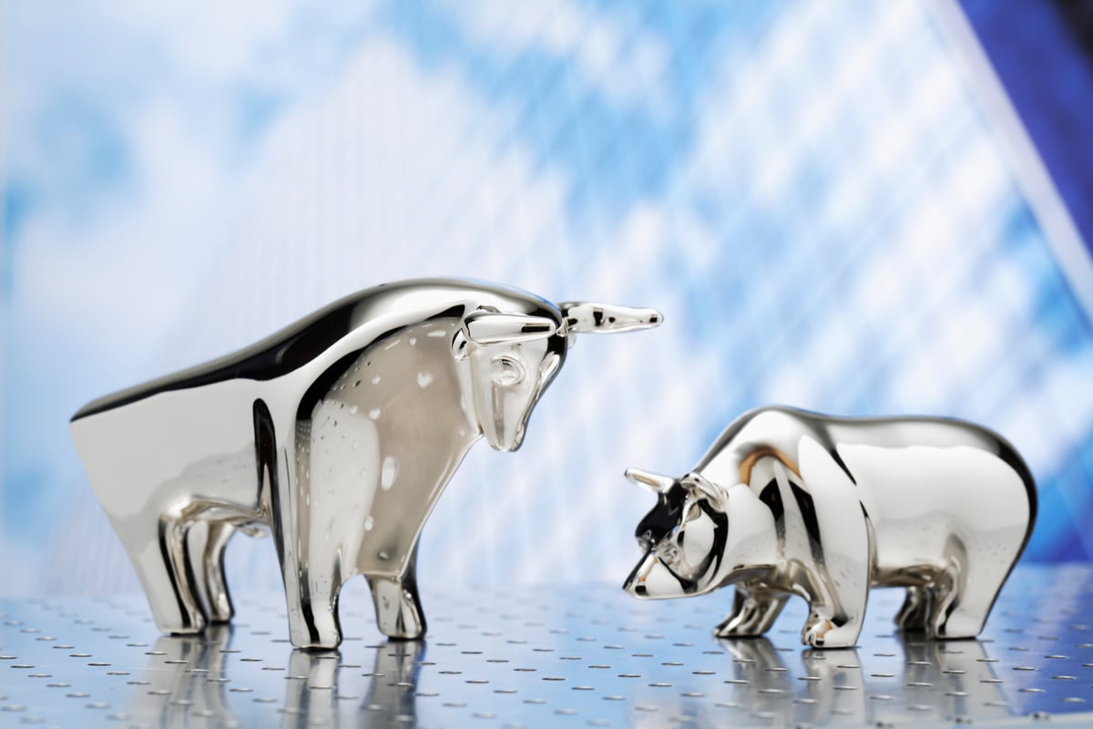Bear and bull figurines facing each other.