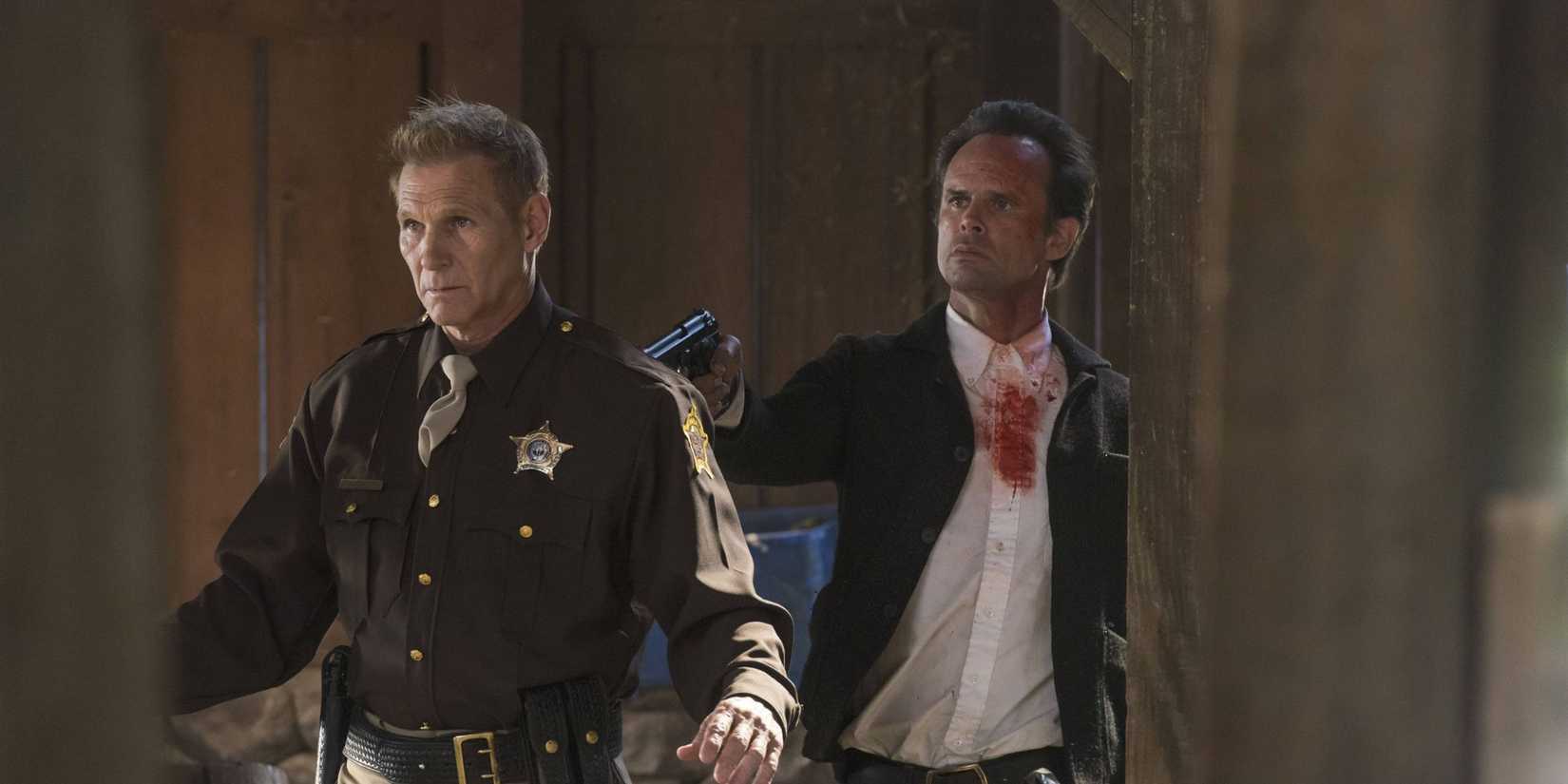 Walton Goggins holding a gun to an officer's back in Justified series finale