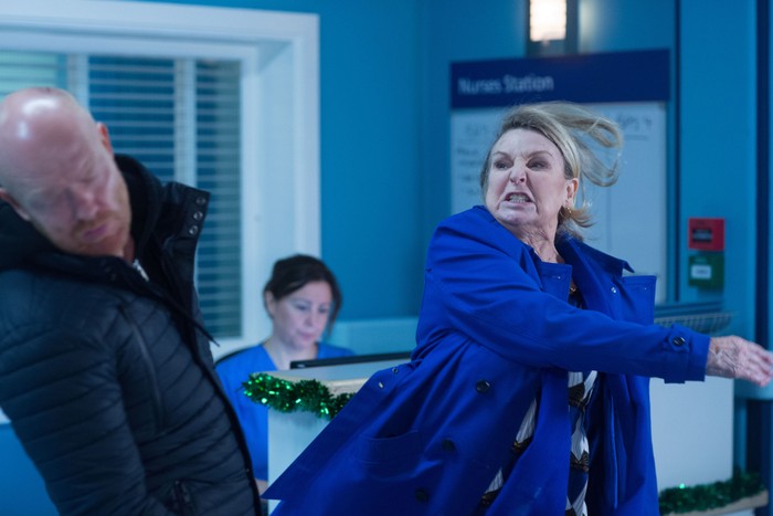 Ann Mitchell as Cora Cross in a blue coat slapping Jake Wood as Max Branning in a hospital scene from 2017 EastEnders.
