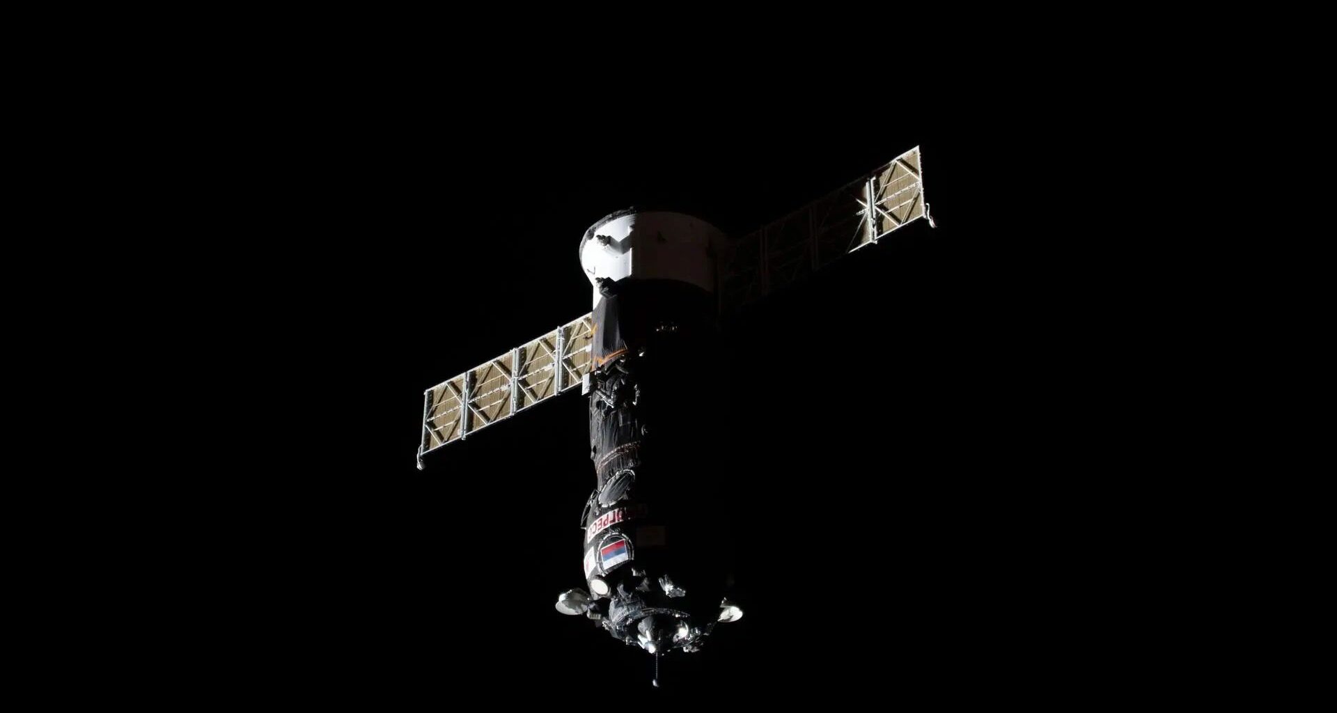 photo of a gray cylindrical spacecraft in deep space
