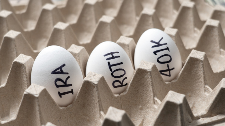 Money and nest eggs concept with white eggs labeled 401k, IRA and ROTH for retirement savings.
