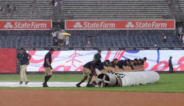 Jul 31, 2025; Bronx, New York, USA; Yankee Stadium grounds crew rolls the tarp onto the infield during a rain delay during the fifth inning between the New York Yankees and the Tampa Bay Rays at Yankee Stadium. Mandatory Credit: Brad Penner-Imagn Images
