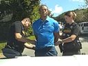 In this image from police body camera video released by the Martin County, Fla., Sheriff's Office, golfer Tiger Woods is taken into custody by sheriff's deputies following a car crash.