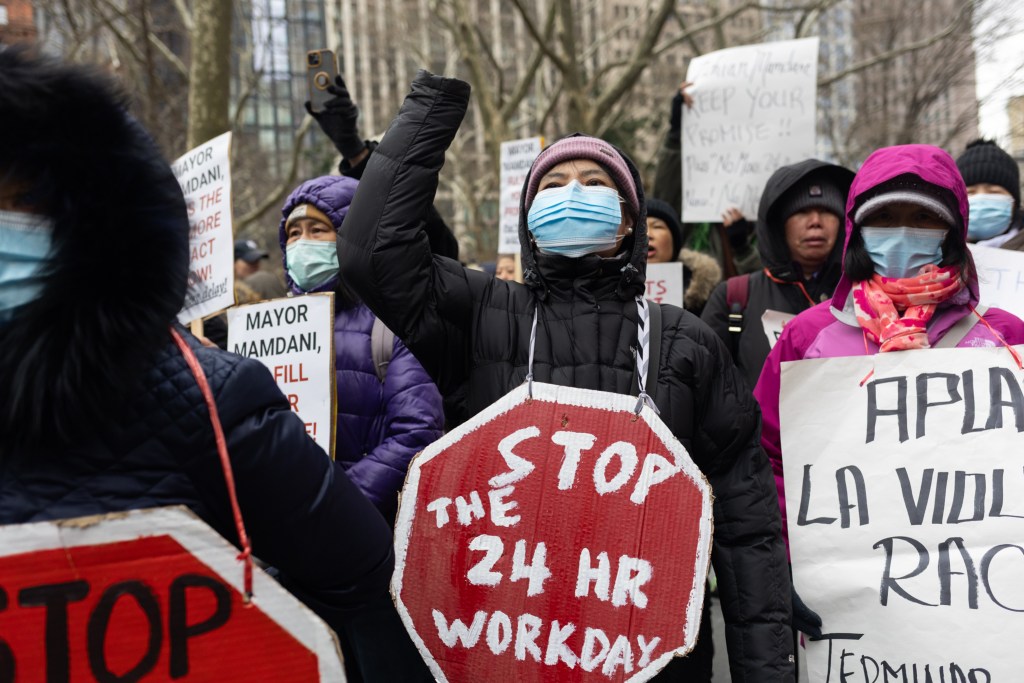 Home health aides rally before starting a sit-in outside City Hall to demand the passage of a bill ending 24-hour shifts