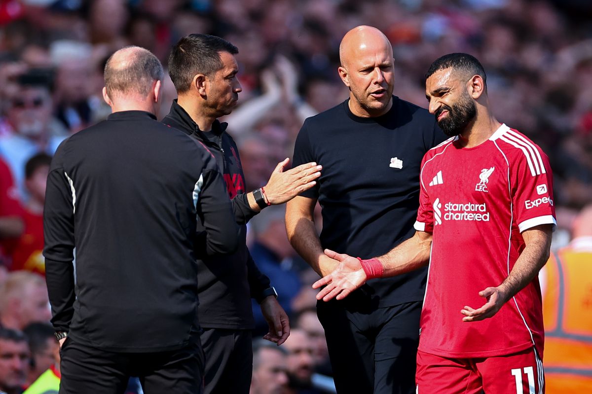 Arne Slot manager / head coach of Liverpool speaks with Mohamed Salah of Liverpool as he goes off injured  