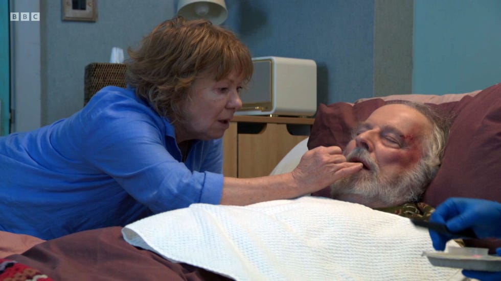 EastEnders, Julie and Nigel Bates eastenders, julie next to nigel in bed, applying lip balm to his face