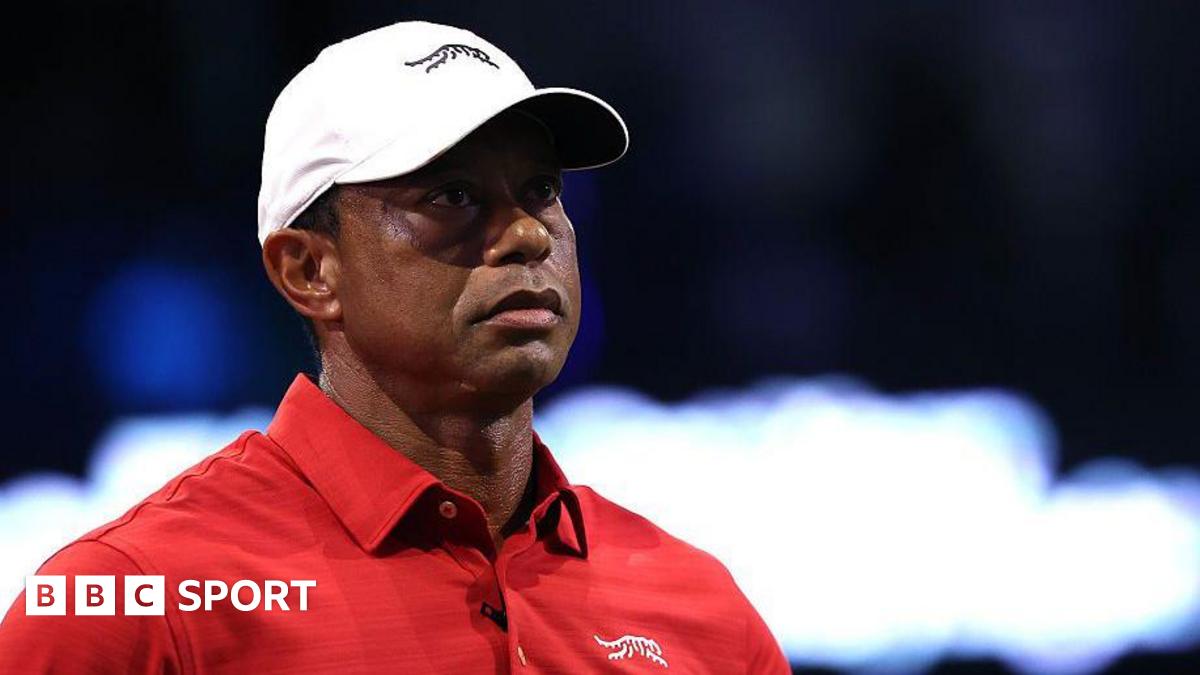 Tiger Woods wears a red T-shirt and a white cap