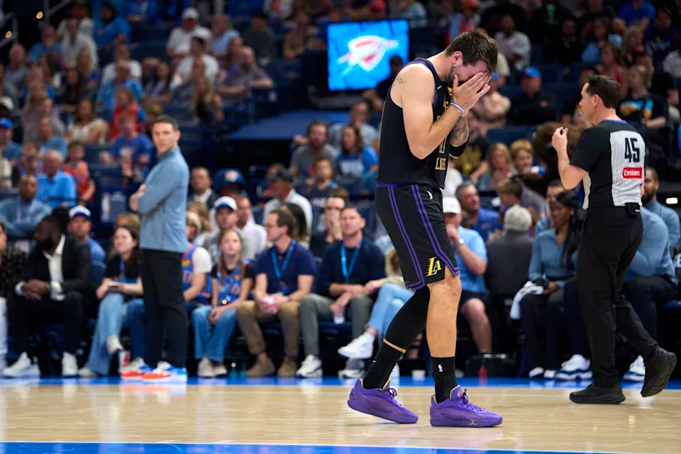 Lakers star Luka Doncic holds his head in his hands while reacting to a play against the Thunder.