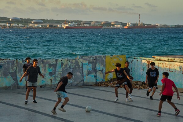 People play soccer in an abandoned swimming pool across from a tanker terminal along the port of Matanzas, Cuba, Monday, March 30, 2026. (AP Photo/Ramon Espinosa)