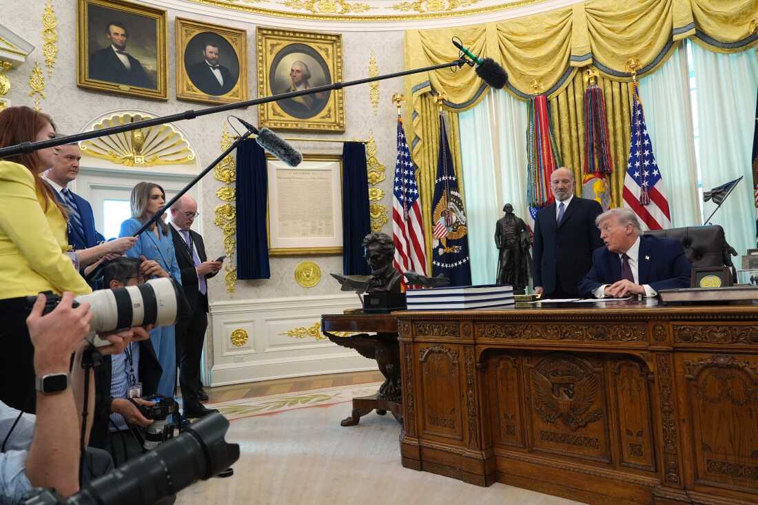 President Donald Trump answers questions from reporters after signing an executive order in the Oval Office of the White House Tuesday, March 31, 2026, in Washington, as Commerce Secretary Howard Lutnick listens.